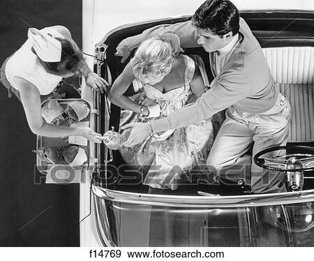 1950S Drive-In Restaurant Carhop Waitress On Roller Skates Serving Couple In 1955 T-Bird Car Burgers And Milkshakes View Large Photo Image Stock Photo - 1950S Drive-In Restaurant Carhop Waitress On Roller Skates Serving Couple In 1955 T-Bird Car Burgers And Milkshakes. Fotosearch