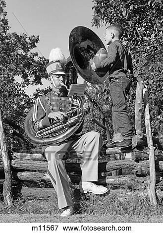 1950S Teen Playing A Tuba Sitting Fence In A Band Uniform Boy Standing On Fence Holding Football Watches View Large Photo Image Stock Photo - 1950S Teen Playing A Tuba Sitting Fence In A Band Uniform Boy Standing On Fence Holding Football Watches. Fotosearch