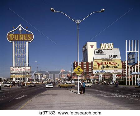 Stock Image - 1970S 1980S The Strip Las Vegas Daytime Y Shaped Streetlight The Dunes Casino Sign Mgm Hilton Barbary Coast. Fotosearch