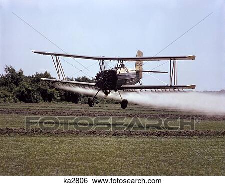 1970S Grumman Airplane Crop Dusting Spraying Herbicide On Rice Field In Chambers County Texas View Large Photo Image Stock Photograph - 1970S Grumman Airplane Crop Dusting Spraying Herbicide On Rice Field In Chambers County Texas . Fotosearch