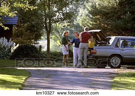 1980S People Loading Trunk Leaving On Automobile Trip Saying Goodbye In Suburban Driveway View Large Photo Image Stock Photo - 1980S People Loading Trunk Leaving On Automobile Trip Saying Goodbye In Suburban Driveway. Fotosearch