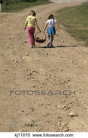 1980S Two Girls Walking Down Dirt Road Carrying Basket View Large Photo Image Stock Image - 1980S Two Girls Walking Down Dirt Road Carrying Basket . Fotosearch
