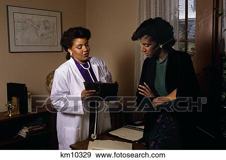1990S African American Female Doctor Talking With Woman Patient View Large Photo Image Stock Photo - 1990S African American Female Doctor Talking With Woman Patient . Fotosearch