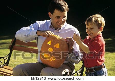 1990S Father And Son Carving A Halloween Pumpkin Outdoors View Large Photo Image Stock Image - 1990S Father And Son Carving A Halloween Pumpkin Outdoors. Fotosearch