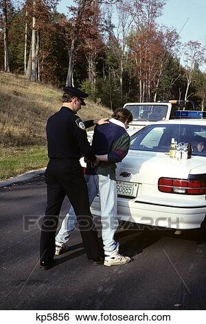 1990S Police Officer Arresting Cuffing Motorist For Drunk Driving View Large Photo Image Stock Photograph - 1990S Police Officer Arresting Cuffing Motorist For Drunk Driving. Fotosearch