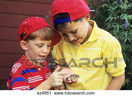 Stock Image - 1990S Two Boys Holding Frog . Fotosearch