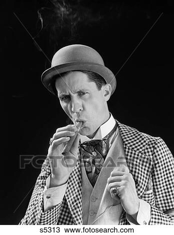 1910S 1920S Portrait Serious Character Con Man Bowler Hat Fancy Suit Cravat Smoking Cigar View Large Photo Image Stock Image - 1910S 1920S Portrait Serious Character Con Man Bowler Hat Fancy Suit Cravat Smoking Cigar . Fotosearch