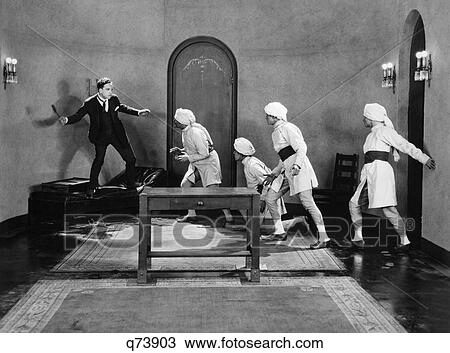 1920S Man In Suit And Tie Being Chased By Gang Of Thugs Wearing Turbans Silent Movie Still View Large Photo Image Stock Image - 1920S Man In Suit And Tie Being Chased By Gang Of Thugs Wearing Turbans Silent Movie Still. Fotosearch