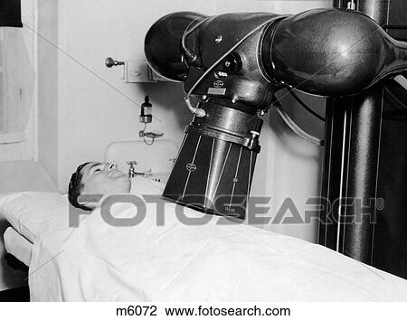 Stock Image - 1930S 1940S Man Patient Undergoing Xray Machine Procedure Pennsylvania Hospital Philadelphia Pa Usa. Fotosearch