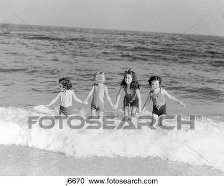 1930S 4 Little Girls Standing Surf Waves Ocean Beach Shore Fun Summer Swim View Large Photo Image Stock Image - 1930S 4 Little Girls Standing Surf Waves Ocean Beach Shore Fun Summer Swim . Fotosearch