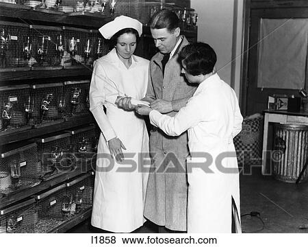 1930S Two Nurses And Lab Technician Man Women In Hospital Laboratory Reviewing Notes View Large Photo Image Stock Photo - 1930S Two Nurses And Lab Technician Man Women In Hospital Laboratory Reviewing Notes . Fotosearch