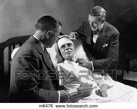 1940S Male Patient Hospital Bed Head Wrapped Bandage Being Attended To By Two Men Doctors View Large Photo Image Stock Photograph - 1940S Male Patient Hospital Bed Head Wrapped Bandage Being Attended To By Two Men Doctors . Fotosearch