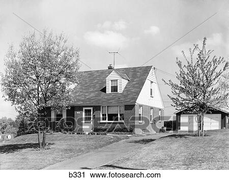 Stock Image - 1950S Brick Two Story Suburban Home Separate 2 Car Garage Television Aerial Antenna On Roof. Fotosearch