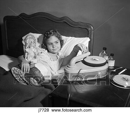 1950S Girl Sick In Bed Playing Records Holding Baby Doll View Large Photo Image Stock Photo - 1950S Girl Sick In Bed Playing Records Holding Baby Doll. Fotosearch