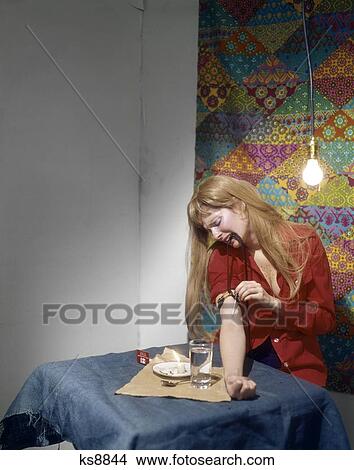 1960S 1970S 1980S Blonde Woman Needle In Arm Shooting Up Heroin In Shabby Apartment View Large Photo Image Picture - 1960S 1970S 1980S Blonde Woman Needle In Arm Shooting Up Heroin In Shabby Apartment . Fotosearch