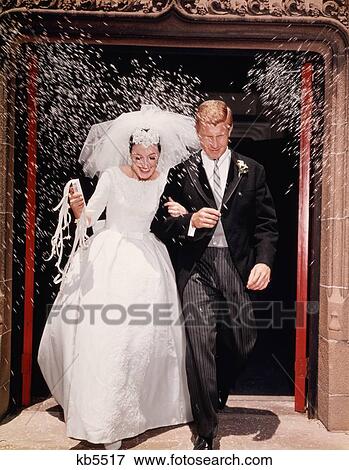 Stock Photo - 1960S Just Married Bride And Groom Leaving Church Under Shower Of Rice. Fotosearch