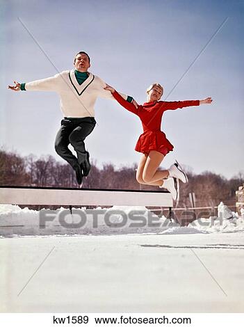 1960S Man And Woman Ice Skaters Jumping In The Air Off The Ice Looking At Camera Wearing Skating Outfits View Large Photo Image Stock Photo - 1960S Man And Woman Ice Skaters Jumping In The Air Off The Ice Looking At Camera Wearing Skating Outfits . Fotosearch