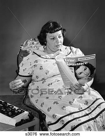 1960S Overweight Woman Eating Candy And Reading True Romance Magazine View Large Photo Image Stock Photograph - 1960S Overweight Woman Eating Candy And Reading True Romance Magazine . Fotosearch