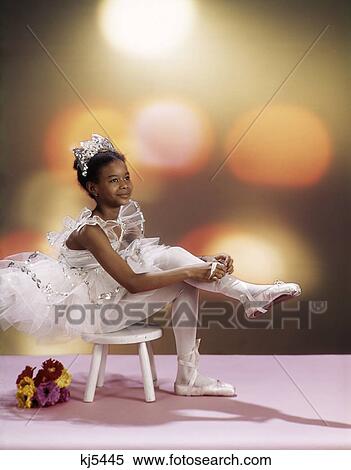 1970S African-American Girl Sitting On Stool Wearing White Tutu Costume Putting On Ballet Toe Shoes View Large Photo Image Stock Photography - 1970S African-American Girl Sitting On Stool Wearing White Tutu Costume Putting On Ballet Toe Shoes . Fotosearch