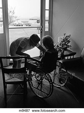 1970S Anonymous Silhouetted Nurse Helping Elderly Person Sitting In Wheelchair All In Silhouette View Large Photo Image Stock Photo - 1970S Anonymous Silhouetted Nurse Helping Elderly Person Sitting In Wheelchair All In Silhouette . Fotosearch