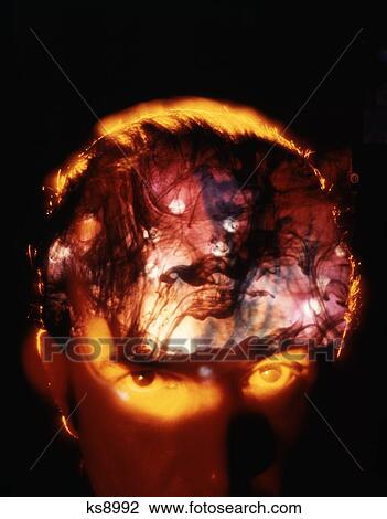 1970S Mans Forehead And Face Looking At Camera With Bizarre Smoky Fiery Swirl Patterns Inside Skull Evil Trouble Madness Drugs View Large Photo Image Stock Image - 1970S Mans Forehead And Face Looking At Camera With Bizarre Smoky Fiery Swirl Patterns Inside Skull Evil Trouble Madness Drugs. Fotosearch