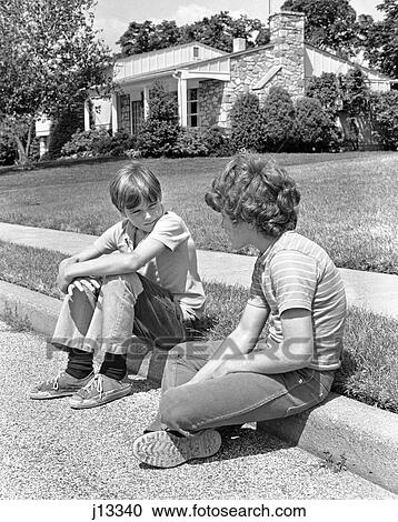 1970S Two Early Teenage Boys Sitting On Curb Suburban Neighborhood Talking View Large Photo Image Stock Image - 1970S Two Early Teenage Boys Sitting On Curb Suburban Neighborhood Talking. Fotosearch
