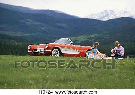 1980S Couple Picnic By 1960 Red White Corvette Grassy Meadow Guitar Winter Park Colorado Usa View Large Photo Image Picture - 1980S Couple Picnic By 1960 Red White Corvette Grassy Meadow Guitar Winter Park Colorado Usa. Fotosearch