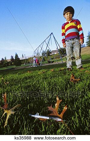 1980S Little Boy Child Looking At Discarded Hypodermic Needle Syringe On Playground View Large Photo Image Stock Photo - 1980S Little Boy Child Looking At Discarded Hypodermic Needle Syringe On Playground . Fotosearch