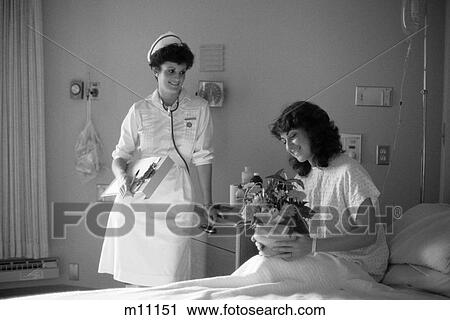 1980S Smiling Female Patient Sitting Up In Hospital Bed Holding Flower Arrangement Smiling Female Nurse Holding Chart Looking On View Large Photo Image Stock Image - 1980S Smiling Female Patient Sitting Up In Hospital Bed Holding Flower Arrangement Smiling Female Nurse Holding Chart Looking On. Fotosearch