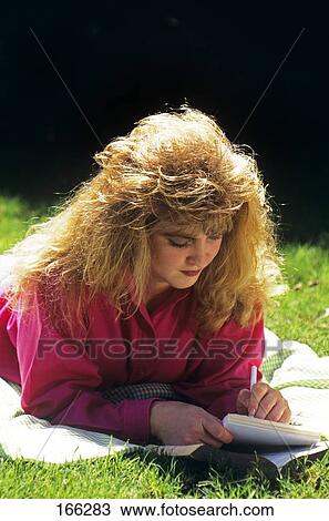 Stock Image - 1980S Teen Girl Outdoors Studying Writing. Fotosearch