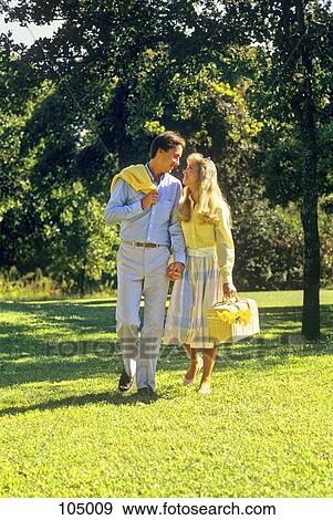 1980S Young Couple Walking Outdoors Carrying Picnic Basket View Large Photo Image Stock Photo - 1980S Young Couple Walking Outdoors Carrying Picnic Basket. Fotosearch