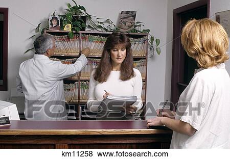 Stock Photo - 1990S 1990S Receptionist Optometrist And Patient At Front Desk. Fotosearch