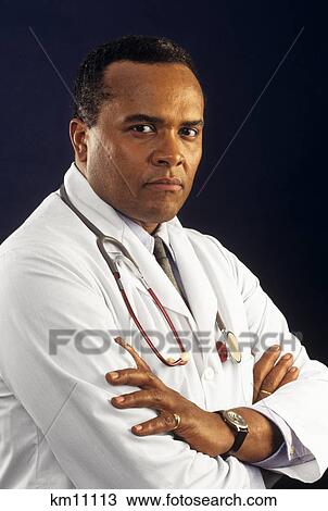 Stock Image - 1990S African American Doctor With Stethoscope Around His Neck Looking At Camera . Fotosearch