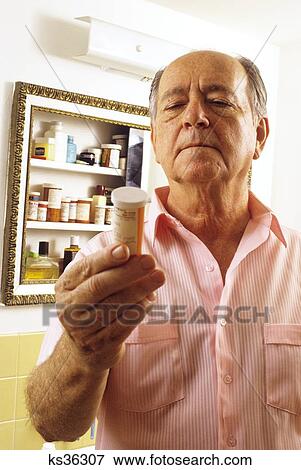 1990S Elderly Man Reading Label On Bottle Of Prescription Medicine View Large Photo Image Stock Photo - 1990S Elderly Man Reading Label On Bottle Of Prescription Medicine . Fotosearch