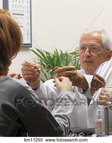 1990S Older Optometrist Fitting Woman With New Glasses View Large Photo Image Stock Photography - 1990S Older Optometrist Fitting Woman With New Glasses . Fotosearch