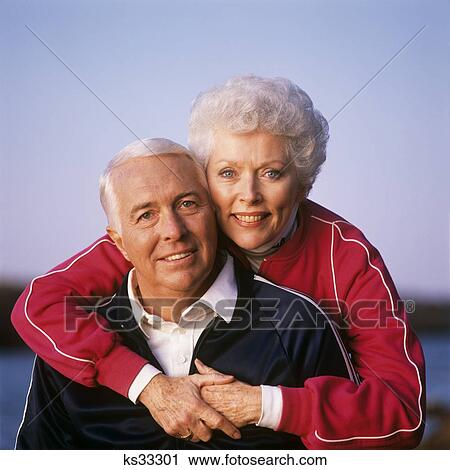1990S Portrait Of Couple In Jogging Suits Looking At Camera Woman Standing With Her Arms Around The Man View Large Photo Image Stock Image - 1990S Portrait Of Couple In Jogging Suits Looking At Camera Woman Standing With Her Arms Around The Man . Fotosearch