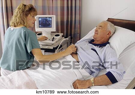 Stock Photo - 1990S Technician Performing Ultrasound On Male Patient . Fotosearch