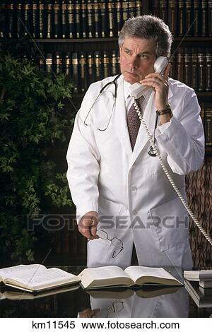 Stock Photography - 1990S Thoughtful Male Doctor On Telephone . Fotosearch