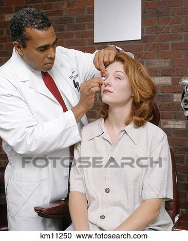 putting optometrist african american caucasian lens eye woman contact fotosearch photography clt009