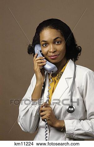 African American Woman Physician Talking On Phone Looking At Camera View Large Photo Image Picture - African American Woman Physician Talking On Phone Looking At Camera. Fotosearch