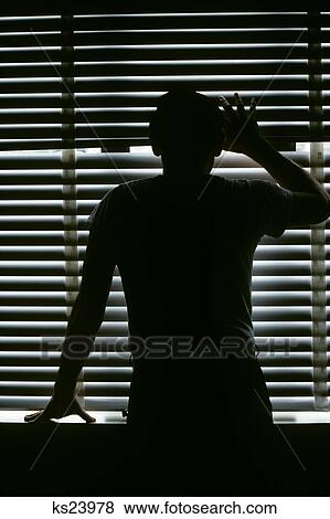 Stock Photo - Anonymous Man In Silhouette Peeking Out Through Closed Window Blinds . Fotosearch