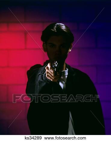 Stock Photo - Anonymous Teen Boy Silhouettes With Handgun Pointed At Camera. Fotosearch
