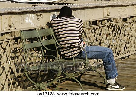 Anonymous Young African American Man Sitting Turned Away Sleeping On Iron Bridge Bench View Large Photo Image Stock Photo - Anonymous Young African American Man Sitting Turned Away Sleeping On Iron Bridge Bench . Fotosearch