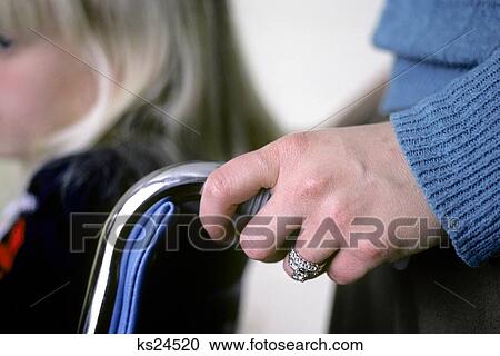 Stock Image - Close-Up Of Mothers Hand Pushing Wheelchair Of Blonde Girl. Fotosearch