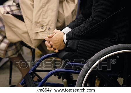 Stock Photo - Double Amputee In Wheelchair Wearing Siuit Jacket Hands Clasped. Fotosearch