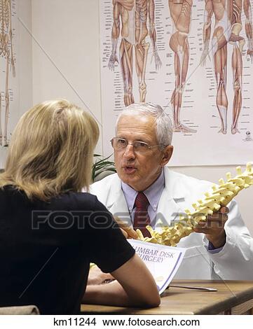 Picture - Male Chiropractor Explaining The Lumbar Spine To Anonymous Female Patient. Fotosearch