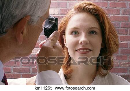 Stock Photography - Older Male Optometrist Examining Woman'S Eyes Closeup . Fotosearch
