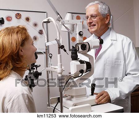 Stock Image - Older Optometrist Examining Woman'S Eyes . Fotosearch