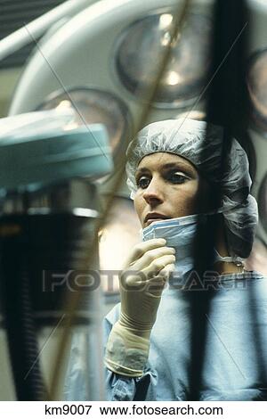 Stock Photo - Operating Room Nurse Lowering Her Surgical Mask. Fotosearch
