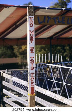 Sign Height Requirement At Amusement Park You Must Be This Tall View Large Photo Image Picture - Sign Height Requirement At Amusement Park You Must Be This Tall. Fotosearch